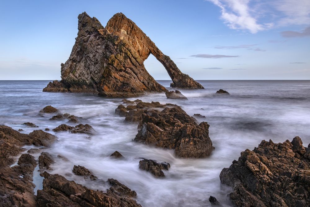 Bow Fiddle Rock - a natural sea arch near Portknockie on the northeast coast of Scotland. It is composed of Quartzite, a metamorphic rock which was originally quartz sandstone. This rock is part of the Cullen Quartzite formation which is seen along the coast between Buckie and Cullen. The formation is some 2,400m thick and dates from the Neoproterozoic Era, 1,000 to 541 million years ago.
