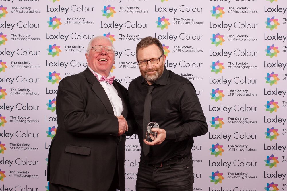 Phil Jones, The Society of Photographers Director presenting the trophy to John. 