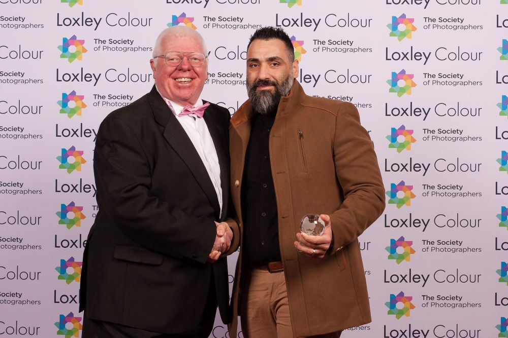 Phil Jones, The Society of Photographers' Director presenting Mario with the trophy.