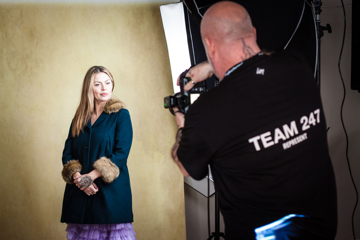 A professional photographer capturing images with a camera in a studio