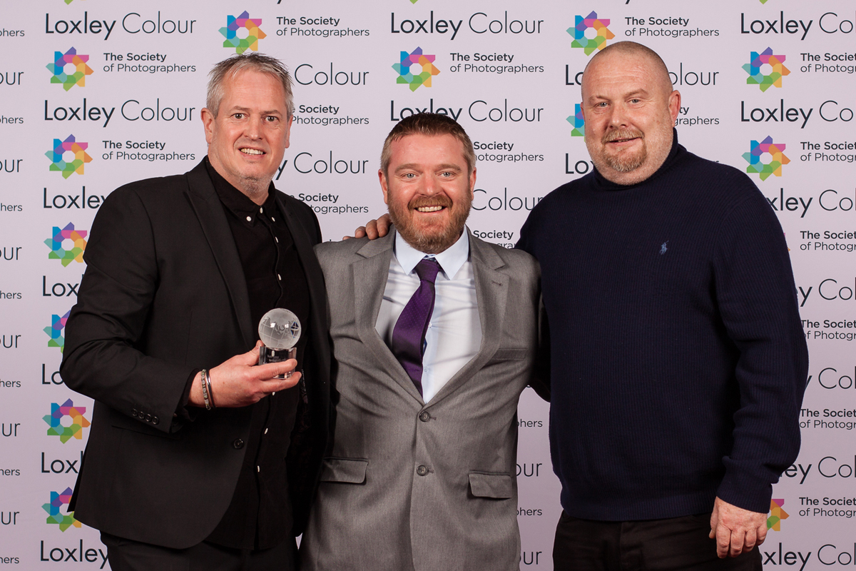 The Best Professional Lighting 2024 "Ben Jones, The Society of Photographers’ Member Value & Experience Manager, presenting Mark Cheetham and Simon Burfoot from Elinchrom UK with The Best Professional Lighting 2024 Award at the ceremony."