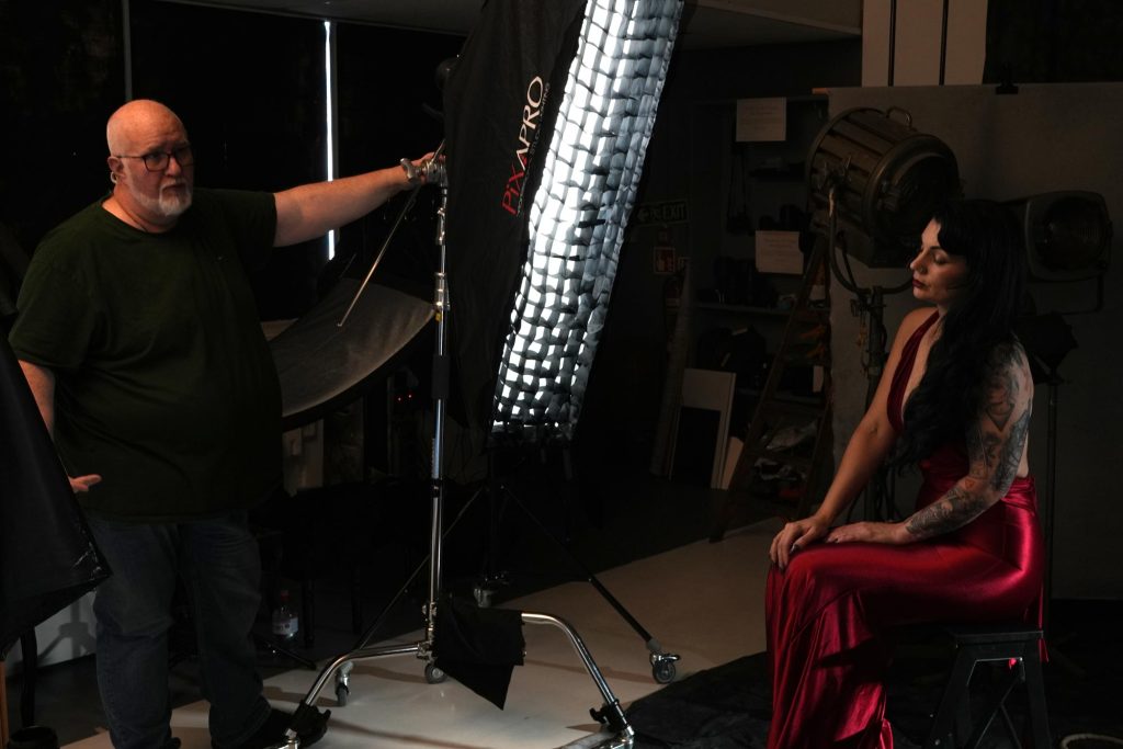 Damian adjusting studio lights to show attendees how modifiers change the mood of an image.