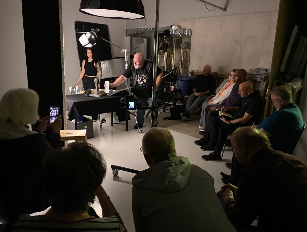 Damian McGillicuddy demonstrating tabletop product photography lighting and composition techniques to attendees at the seminar.