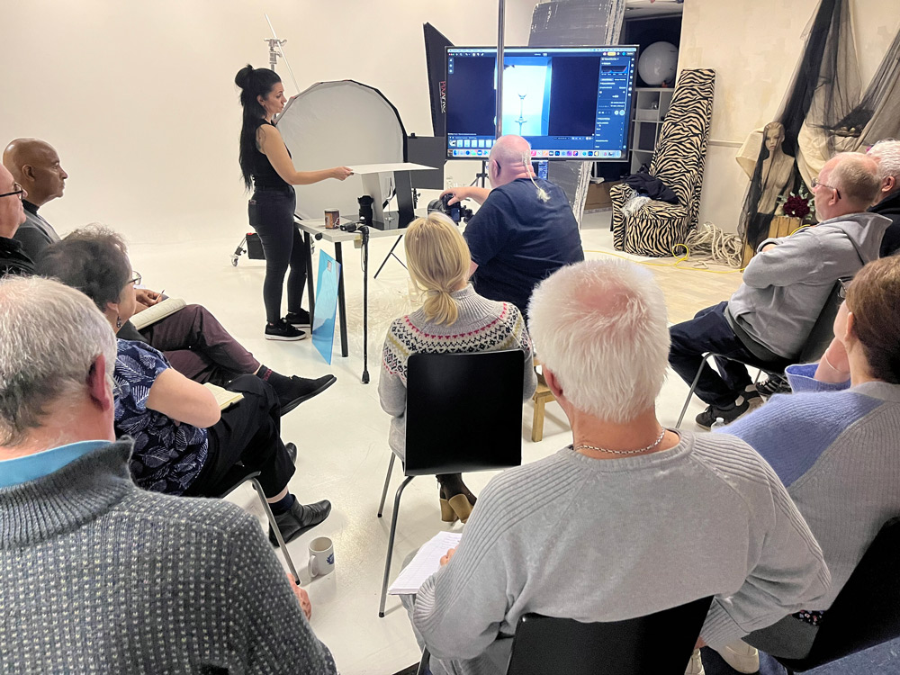 Studio lighting setup showing reflective surfaces, glassware and liquid photography props used during the seminar.